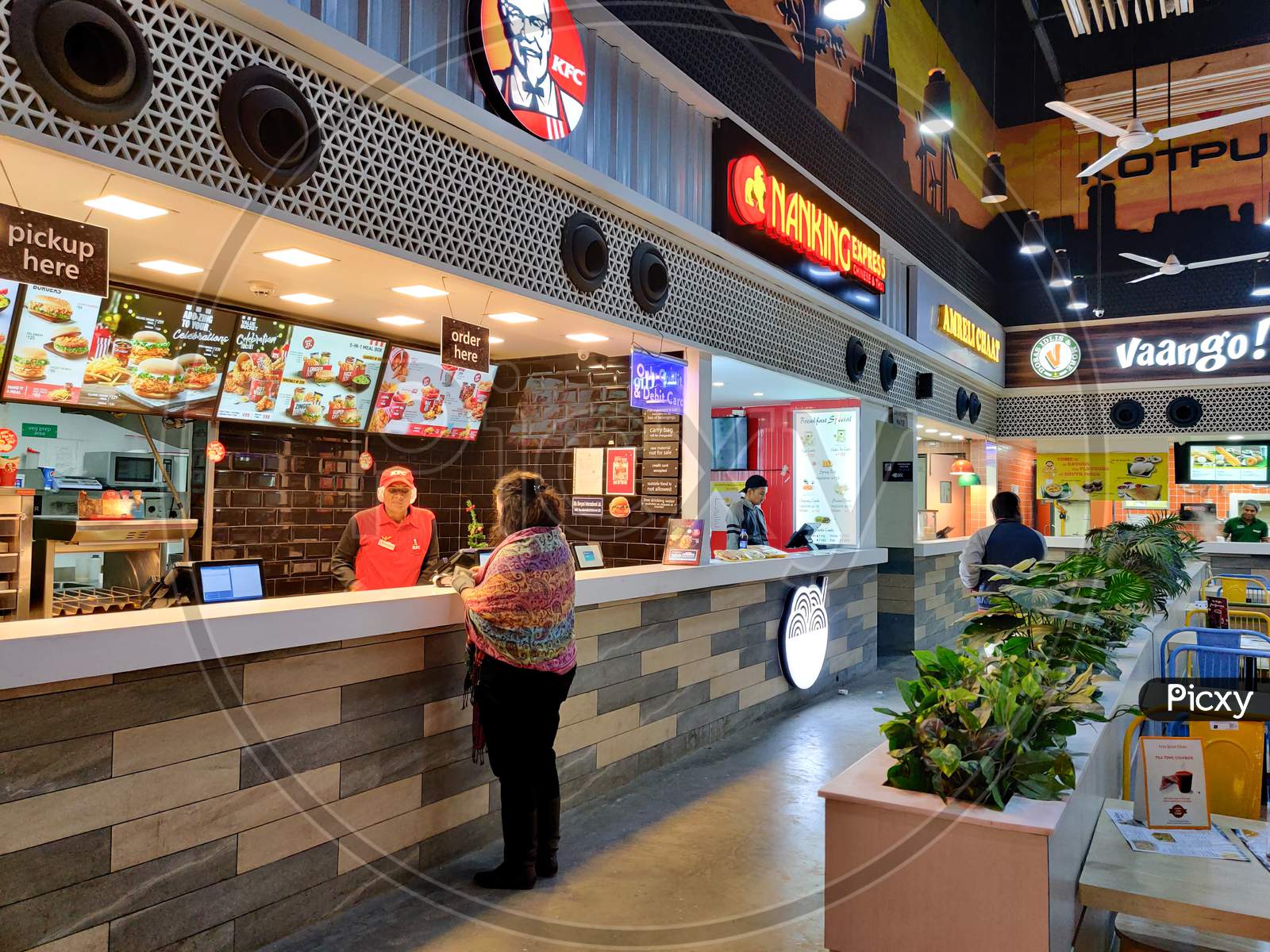Young Indian Woman Ordering Food At A Deserted Food Court Due To The Coronavirus Pandemic Covid19 As Things Open Up With Major Brands Like Kfc, Vaango