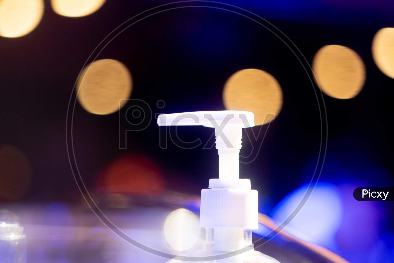 Sanitizer Bottle Nozzle With Out Of Focus Bokeh Balls Showing New Normal In Bars Clubs Restaurants Pubs Post The Coronavirus Covid 19 Pandemic As They Unlock