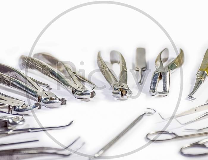 Dental Instruments Arranged On White Table.