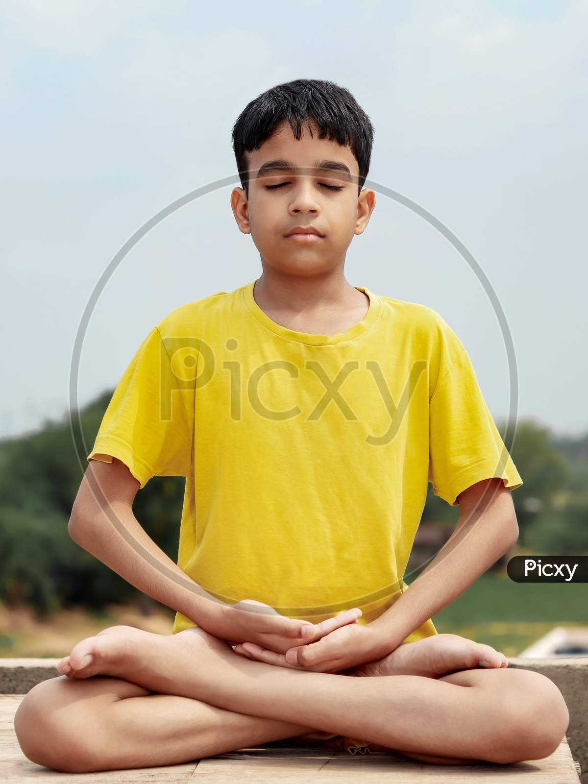 A Young Indian Cute Kid Doing Yoga Lotus Pose  (Padmasana).