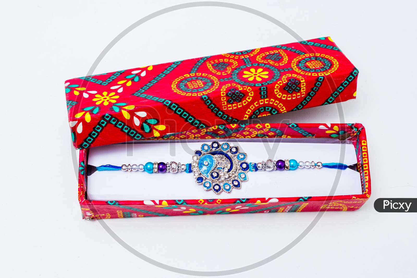 Beautiful Blue Diamond Design Rakhi And Gift Box Over White Background.Raksha Bandhan Festival Is Celebrated In India To Express Love And Bond Between Brother And Sister. Traditional Indian Wrist Band