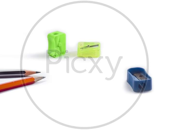 Back To School Concept- A Pencil,Erasor, Sharpner An Cut Foil Of The Pencil On White Table With Or Without Spectacles Not Properly Arranged Isolated.