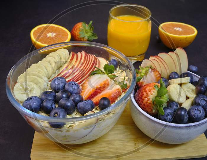 Healthy Breakfast With Fresh Fruits And Juice. Bowl Of colorful Fruits And Oats.