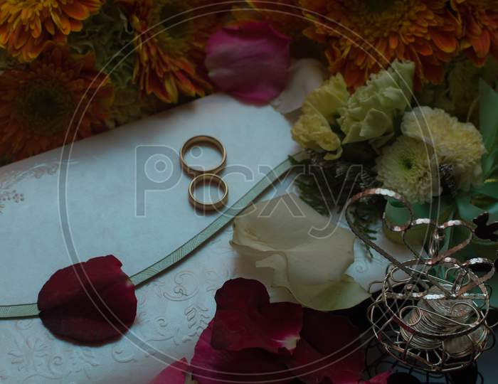 Wedding invitation and rings on the table