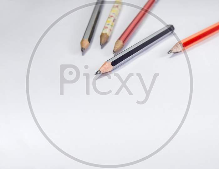 Back To School Concept- A Pencil,Erasor, Sharpner An Cut Foil Of The Pencil On White Table With Or Without Spectacles Not Properly Aranged Isolated.