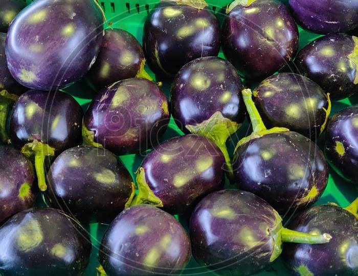 Fresh raw Purple Eggplant in a special green basket