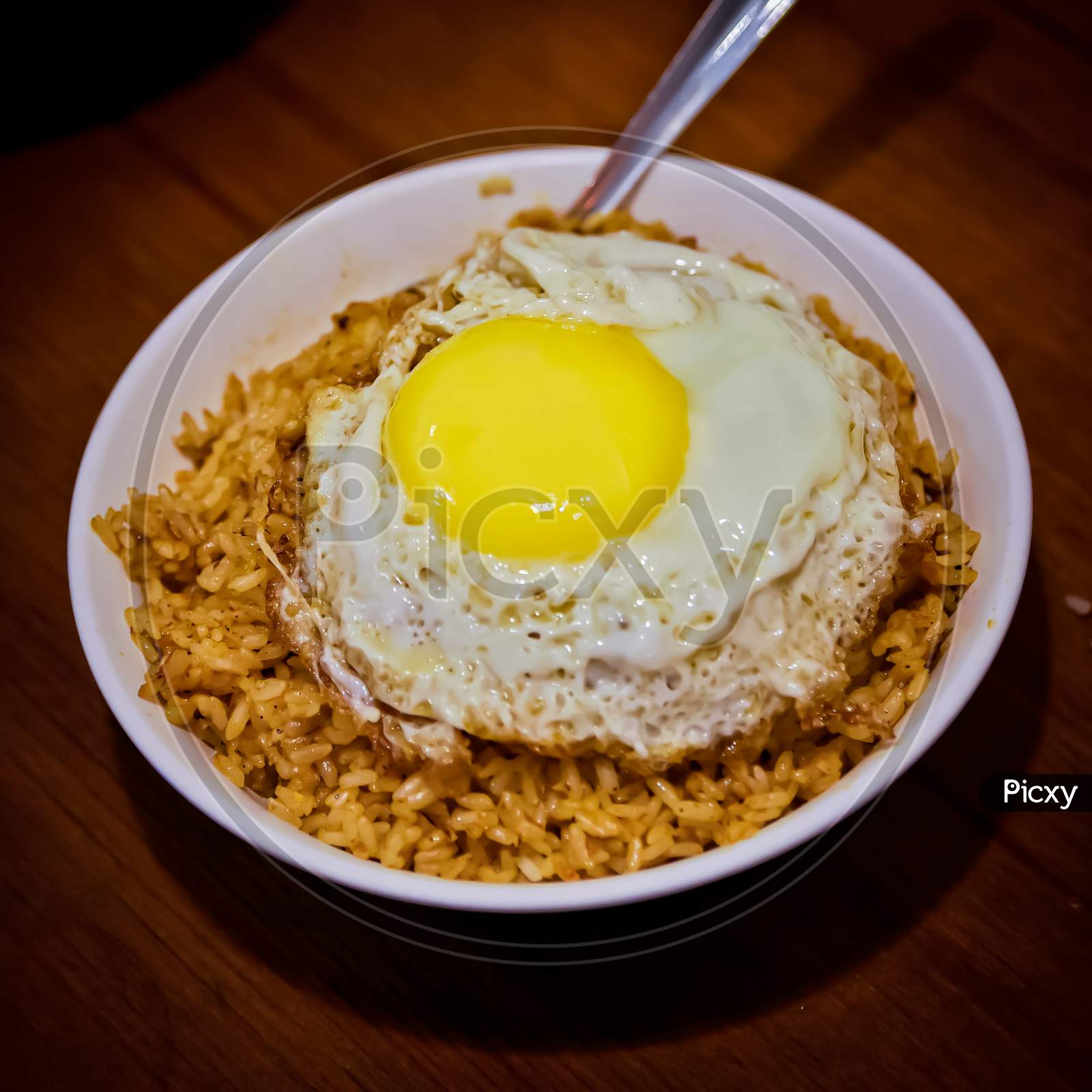 Spicy Schezwan Fried Rice With Fried Egg On Top.