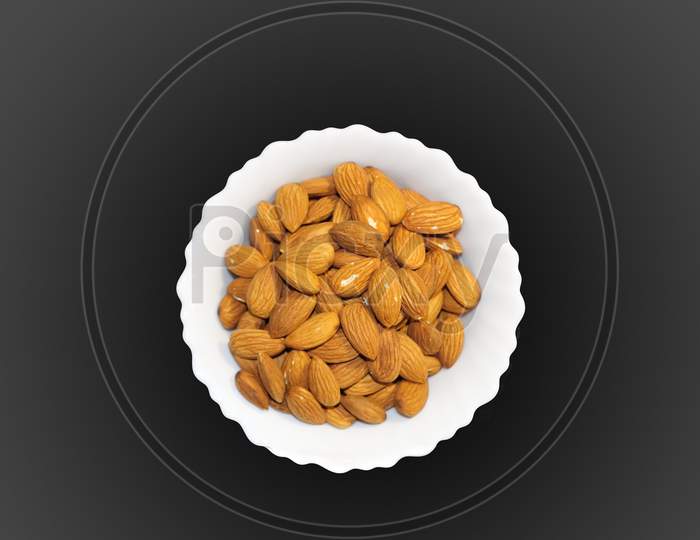 Almond Inside White Bowl. Grey Background