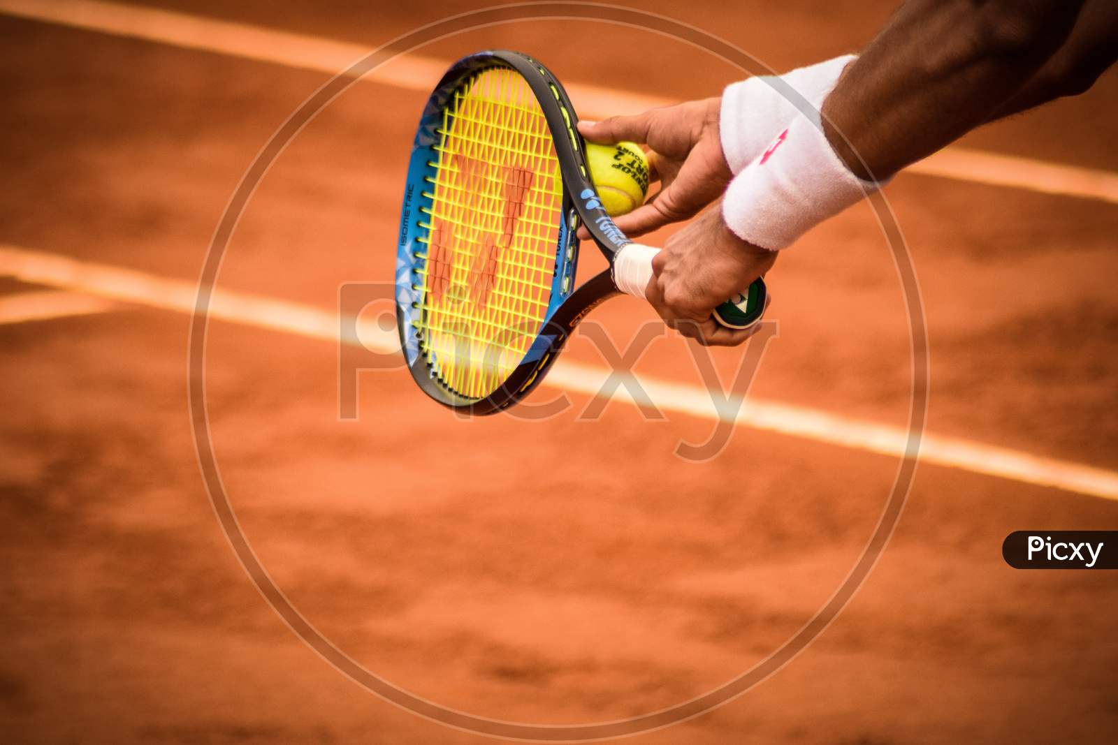 Close-up Photo of Person Holding Tennis Racket and Ball.