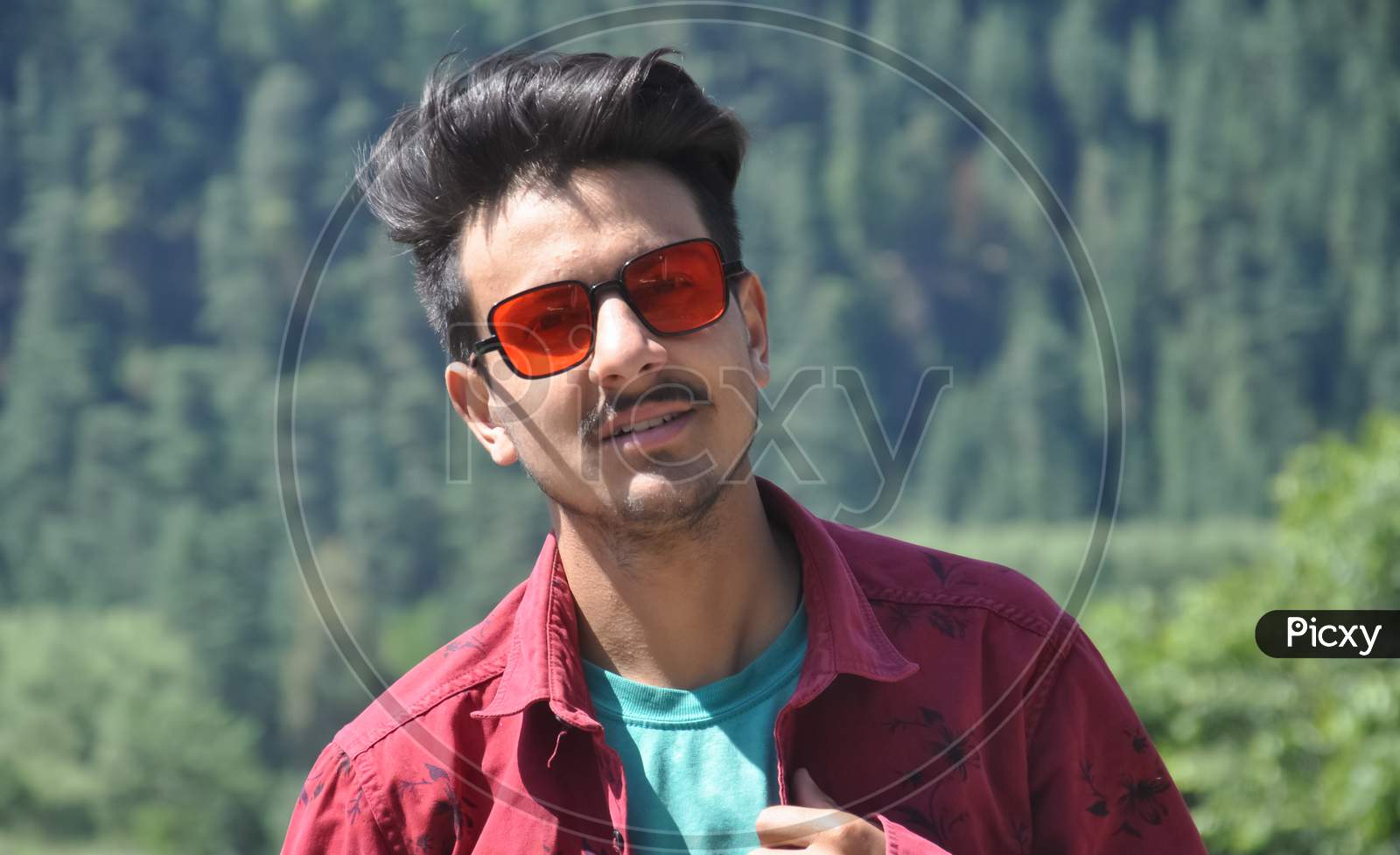 Closeup shot of a North Indian young guy posing outdoor with wearing red shirt and red sunglasses with looking at camera