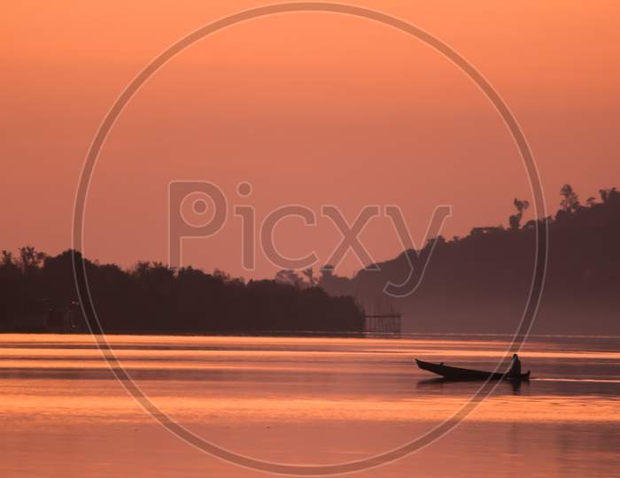 A fisherman returning to home after fishing by paddling row boat on the Sangu river in Bandarban, Bangladesh.