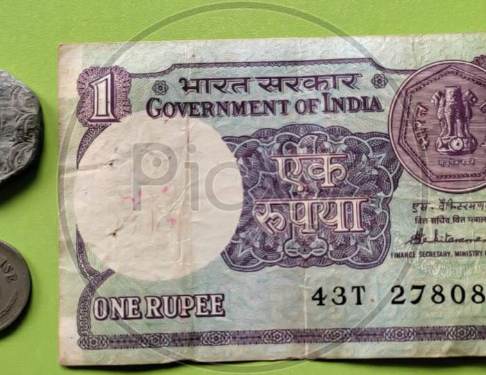 INR Indian currency one rupee note and old coins