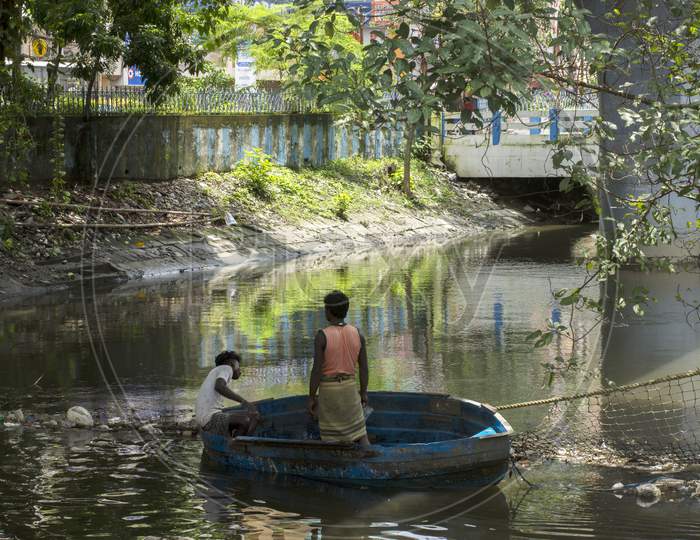 15Th August, 2021, Kolkata, West Bengal, India: A Person On Boat Trying To Clean Canal By Removing Garbage With His Bare Hand In Kolkata, India.
