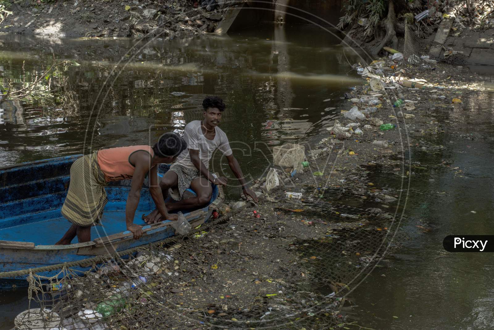 15Th August, 2021, Kolkata, West Bengal, India: 15Th August, 2021, Kolkata, West Bengal, India: Two Persons On Boat Trying To Clean Canal By Removing Garbage With His Bare Hand In Kolkata, India.