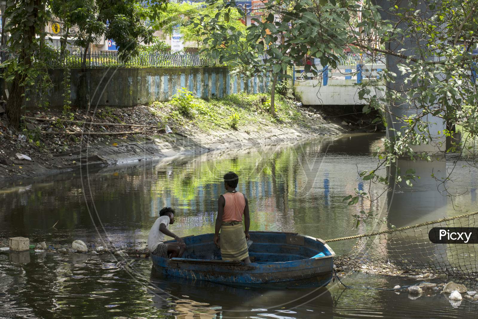 15Th August, 2021, Kolkata, West Bengal, India: A Person On Boat Trying To Clean Canal By Removing Garbage With His Bare Hand In Kolkata, India.