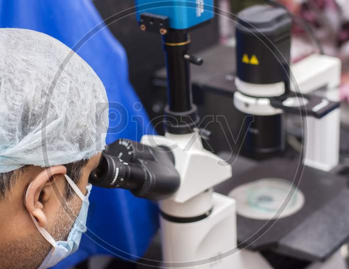 18Th August, 2021, Kolkata, West Bengal,India: A Male Scientist Looking Through Microscope Testing A Bacteria Fungus For Medicine.