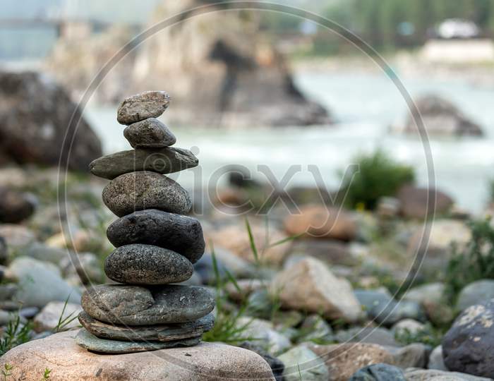 Pyramid Of Round Gray Stones On The Bank Of A Mountain River. Zen And Harmony Concept.Stone Tower