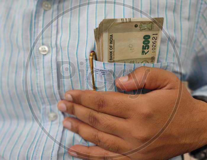 Common Man Secures His Earning By Holding Bundle Of 500 Rupee Notes In This Shirts Pocket.