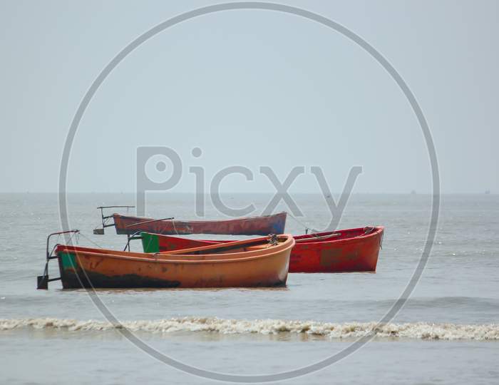 Three multicolored plastic fishing boats anchored  serially at harbor after fishing in chattrogram sea port, Bangladesh