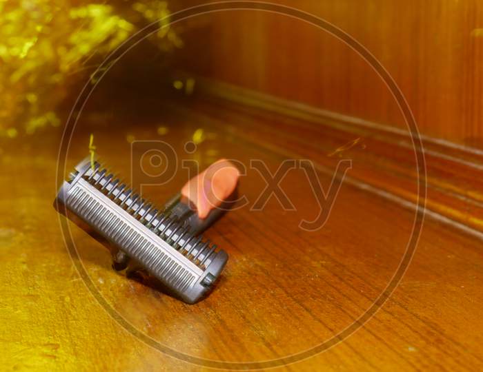 Shaving Razor Tool Isolate On Wooden Surface With Fire Light Sparkle On Background..