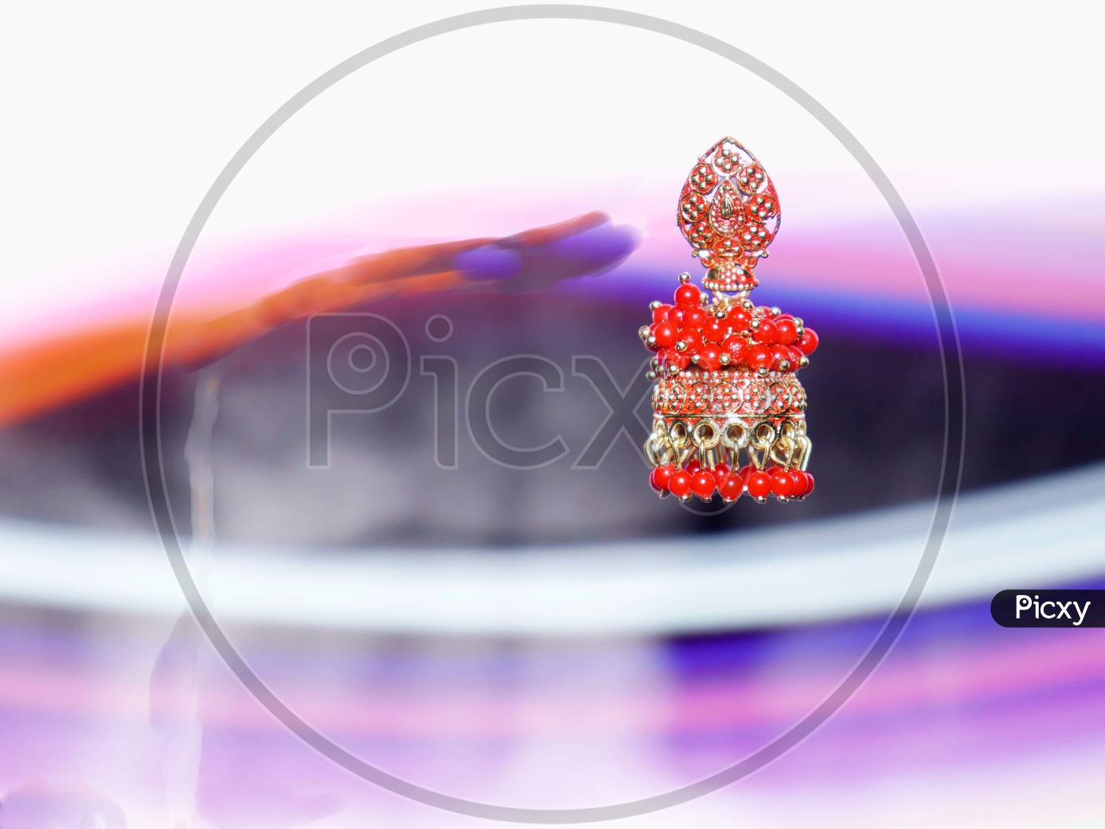 Female Red Color Earrings Presented On Air With Light Effect Shine Backdrop, Commercial Product Presentation Image.