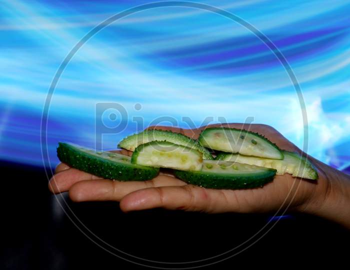 Fresh Organic Sliced Pointed Gourd Pieces Presented On Female Hand With Light Effect Shine Backdrop, Commercial Nature Food Presentation Image.