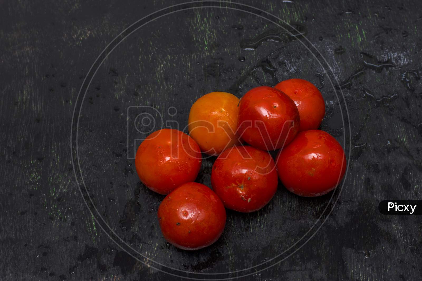 Few Fresh Organic Tomatoes On A Black Background With Selective Focus
