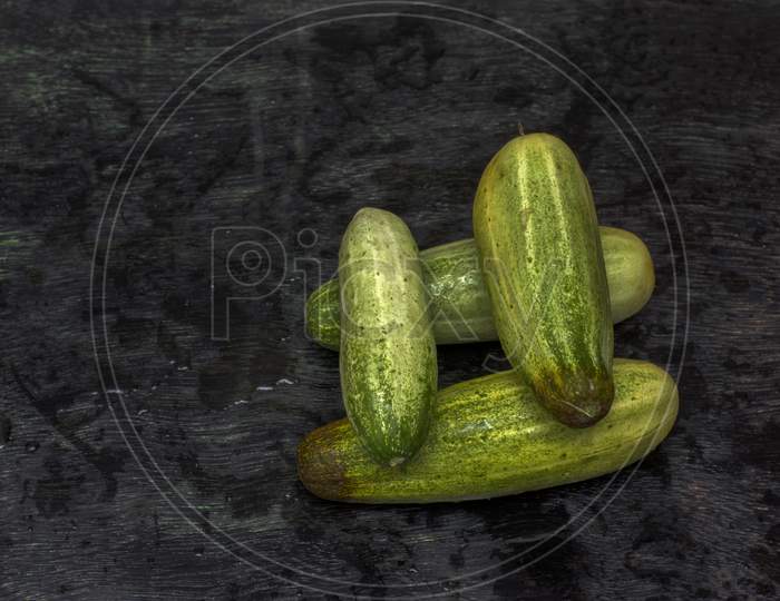 Few Fresh Organic Cucumbers On A Black Background With Selective Focus