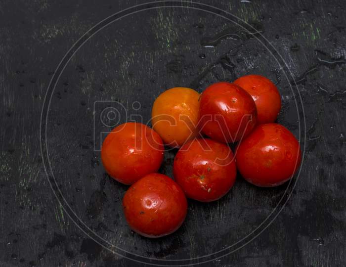 Few Fresh Organic Tomatoes On A Black Background With Selective Focus