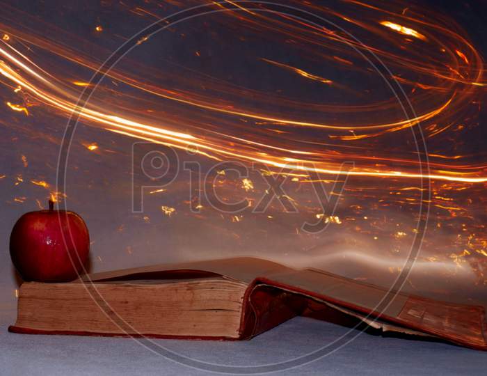 Apple With Book Presentation On Fire Light Background Effect.