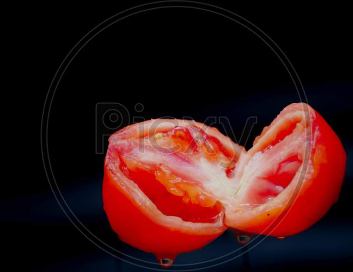 Double Piece Of Sliced Tomato Isolated On Black Background, Organic Commercial Food Image.