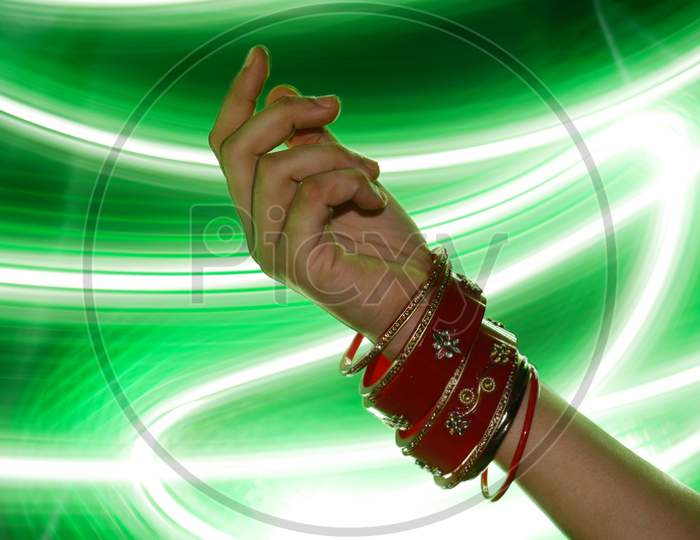 Indian Style Bangles Presented On Girl Hand With Light Effect Shine Backdrop, Commercial Fashion Product Presentation Image.