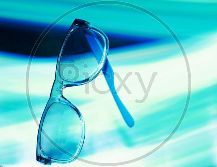 Blueish Sunglasses Presented On Air With Light Effect Shine Backdrop, Commercial Product Presentation Image.