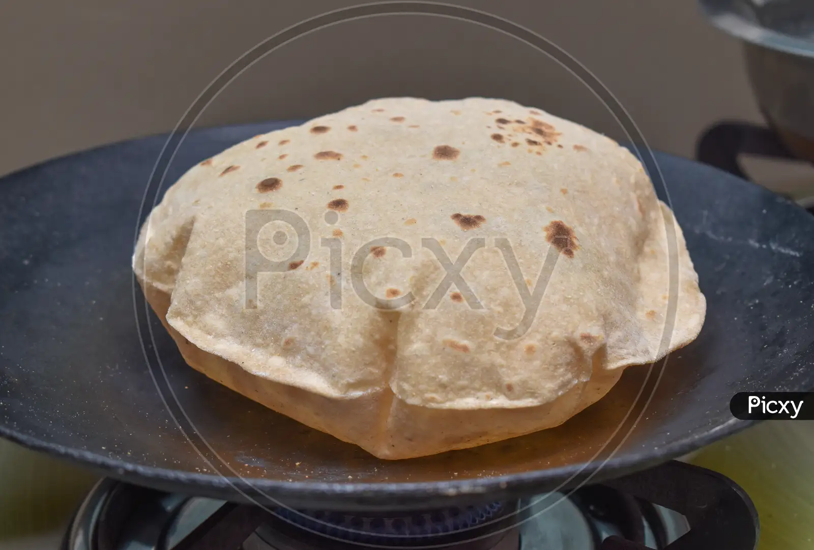 Image of Indian Soft Phulka Chapati (Roti) On Non Stick Tawa Also Known As  Tortilla.-CB807938-Picxy