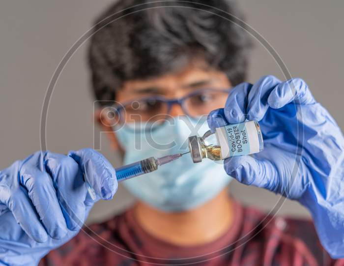 Close Up Of Doctor Hands Holding Covid-19 Vaccine Booster Shot With Syringe - Concept Of Coronavirus 3Rd Dose For Weakened Immune People.