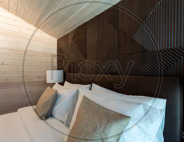 White Bed,  Quilt And Pillows In  Wooden Bedroom.  Hotel Bedroom.  Comfortable Bed With Soft Blanket In Stylish Room