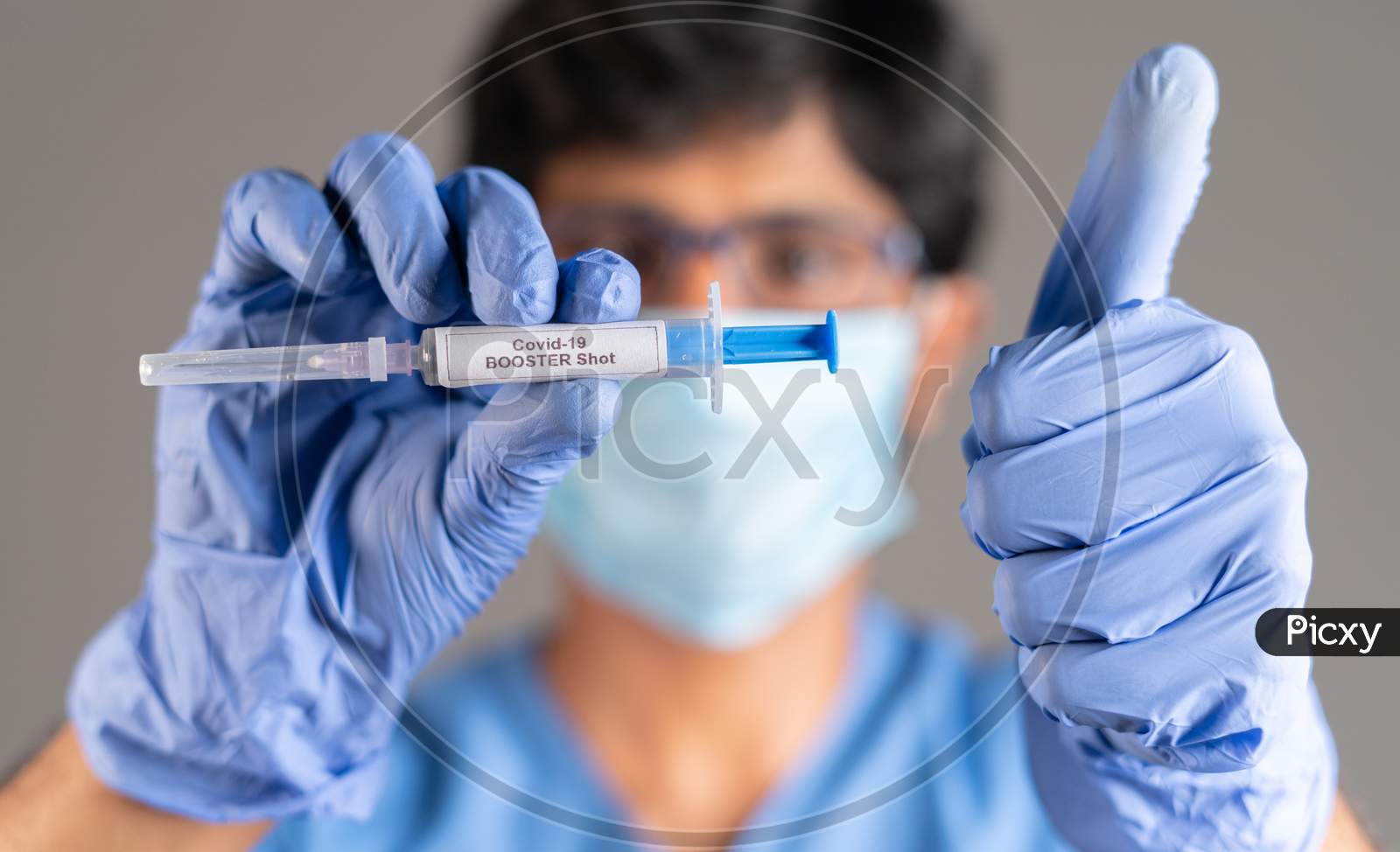 Close Up Of Doctor Hands With Covid-19 Booster Shot Syringe Showing Thumbs Up - Concept Showing Of Recommendation Of 3Rd Dose Vaccination For Immune Weakened People