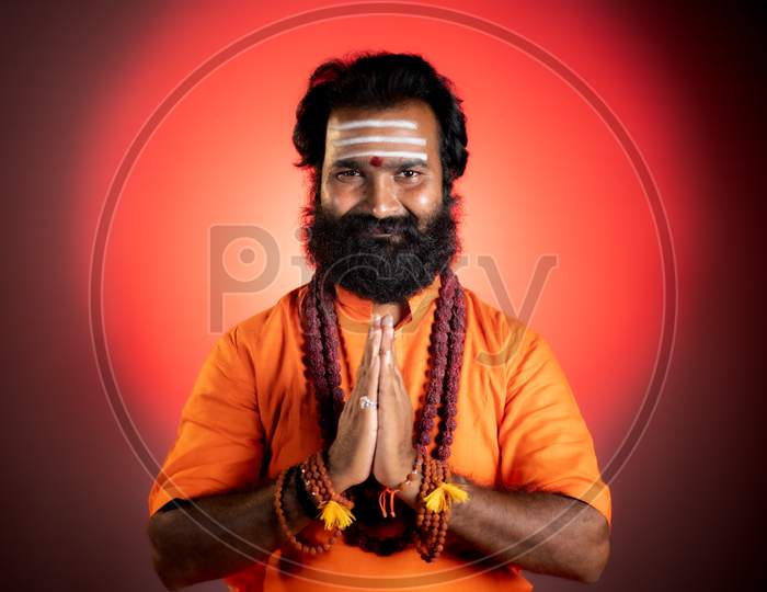 Smiling Indian God Man Or Guru Doing Namaste By Looking At Camera - Concept Showing Of Saint Or Minister Of Hindu Religion
