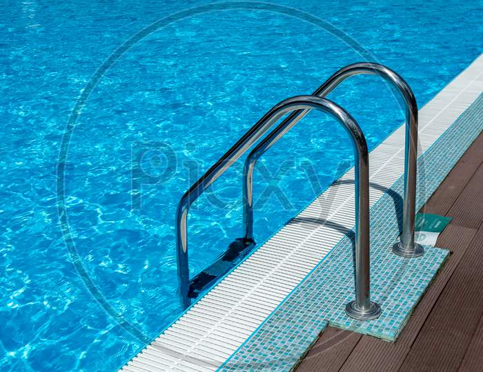 Handrail On Pool. Swimming Pool With Stair At Tropical Resort. Water Swimming Pool With Sunny Reflection. Steel Handrail, Swimming, Summer, Travel. Entry To Pool With Handrail.