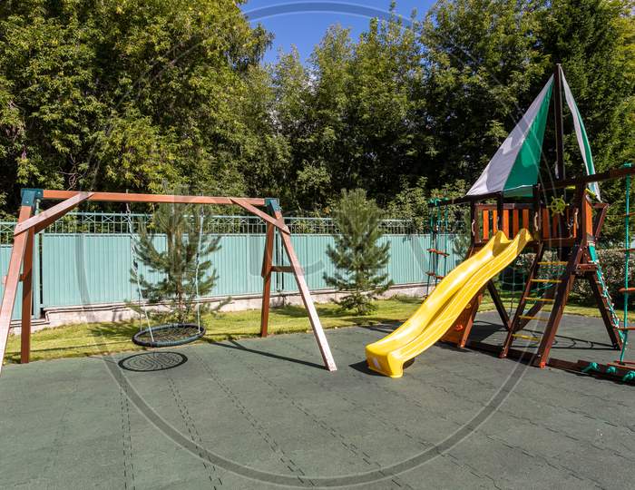 Empty Playground For Children For Leisure And Recreation With A Toy In The Park As A Child In A Natural Style. Playground In A Swing For Mom And Baby