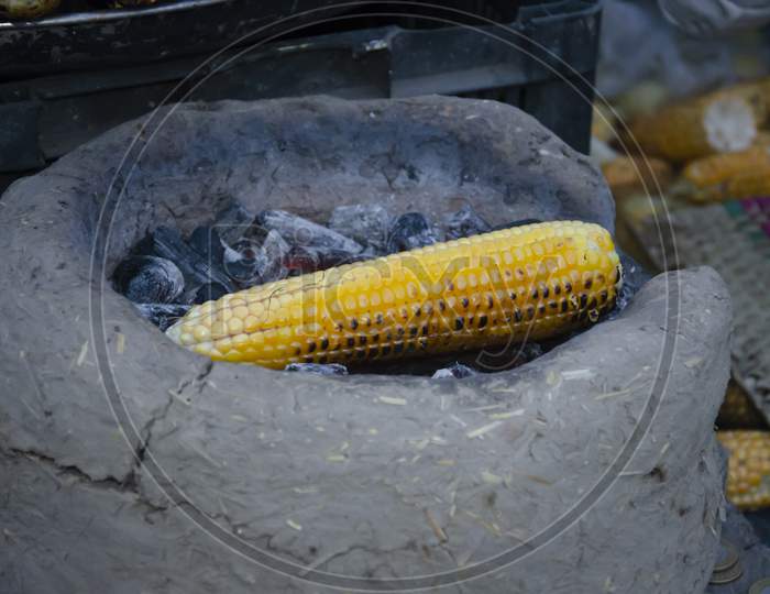 FLAME GRILLED CORN ON THE BURNING COAL. STREET FOOD.
