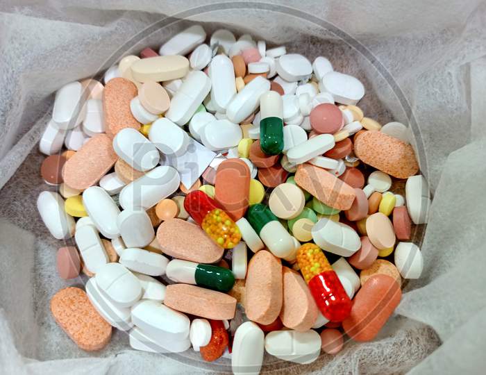 Pictures Of Many Colorful Tablets & Capsules Kept In Tissue Paper.