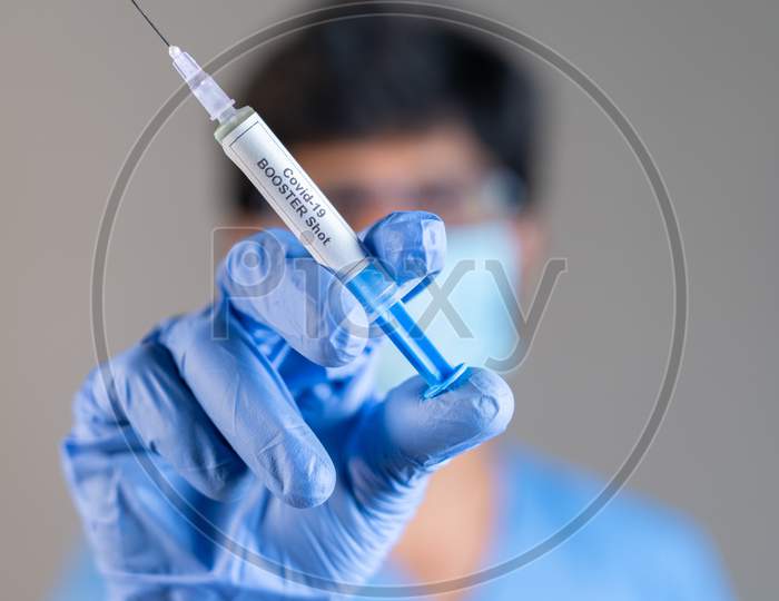 Focus On Syringe, Close Up Of Doctor Or Nurse Hands Holding Covid Vaccination Booster Shot Or 3Rd Dose Syringe.