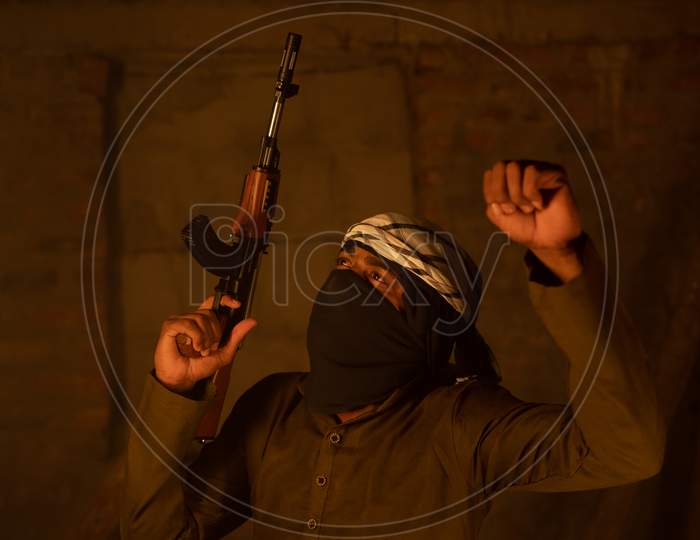 Happy Islamic Militant Or Soldier With Face Cover Dancing With Gun In Hand For Victory In War