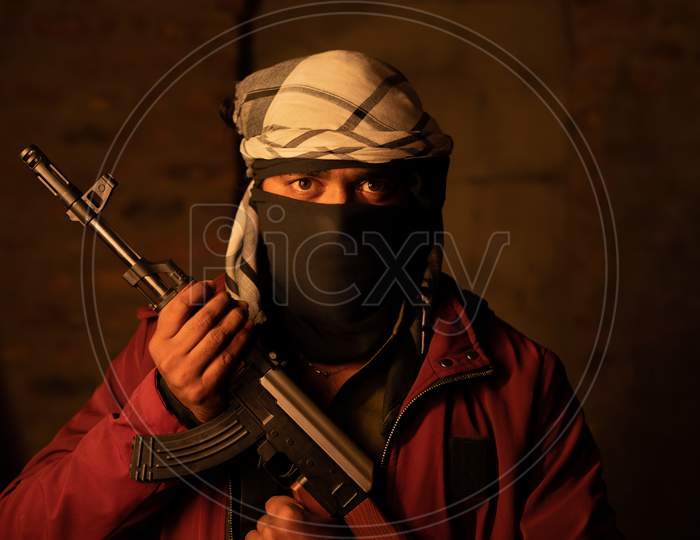 Portrait Of Angry Islamic Militant Or Soldier With Face Cover By Holding Gun Looking At Camera