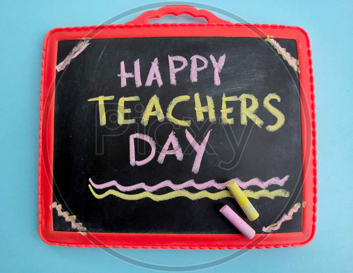 Happy Teachers Day Written With Colorful Chalk On Slate Or Black Board For 5Th September.