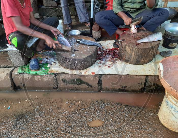 Two Indian Men Cleaning Fish On Roadside To Cut And Prepare For Cooking