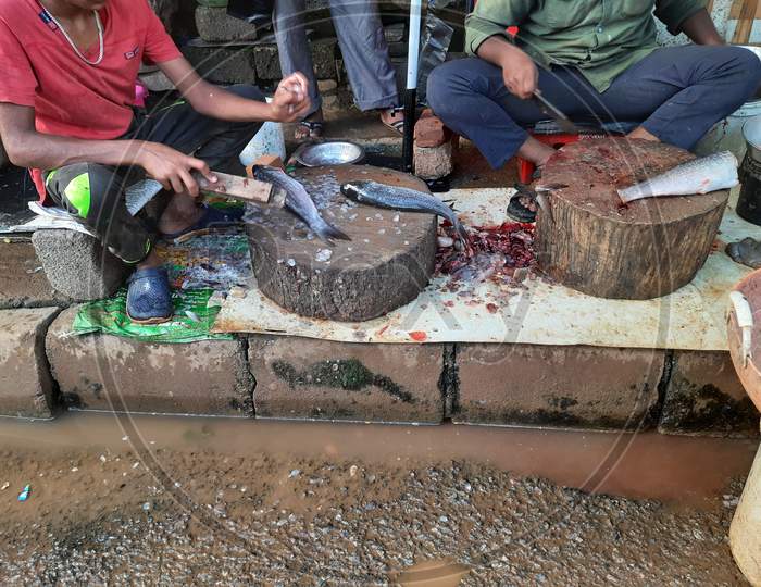 Two Indian Men Cleaning Fish On Roadside To Cut And Prepare For Cooking