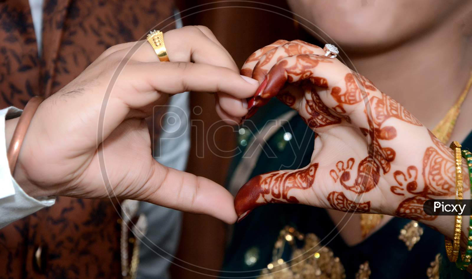 Young Newlywed Couple Making A Heart Gesture With Their Hands