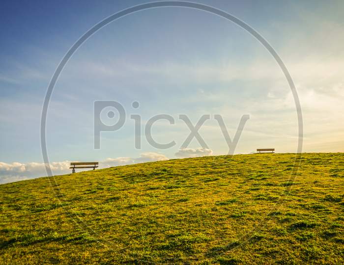 Silhouette Of A Woman Sitting On A Sunset Hill